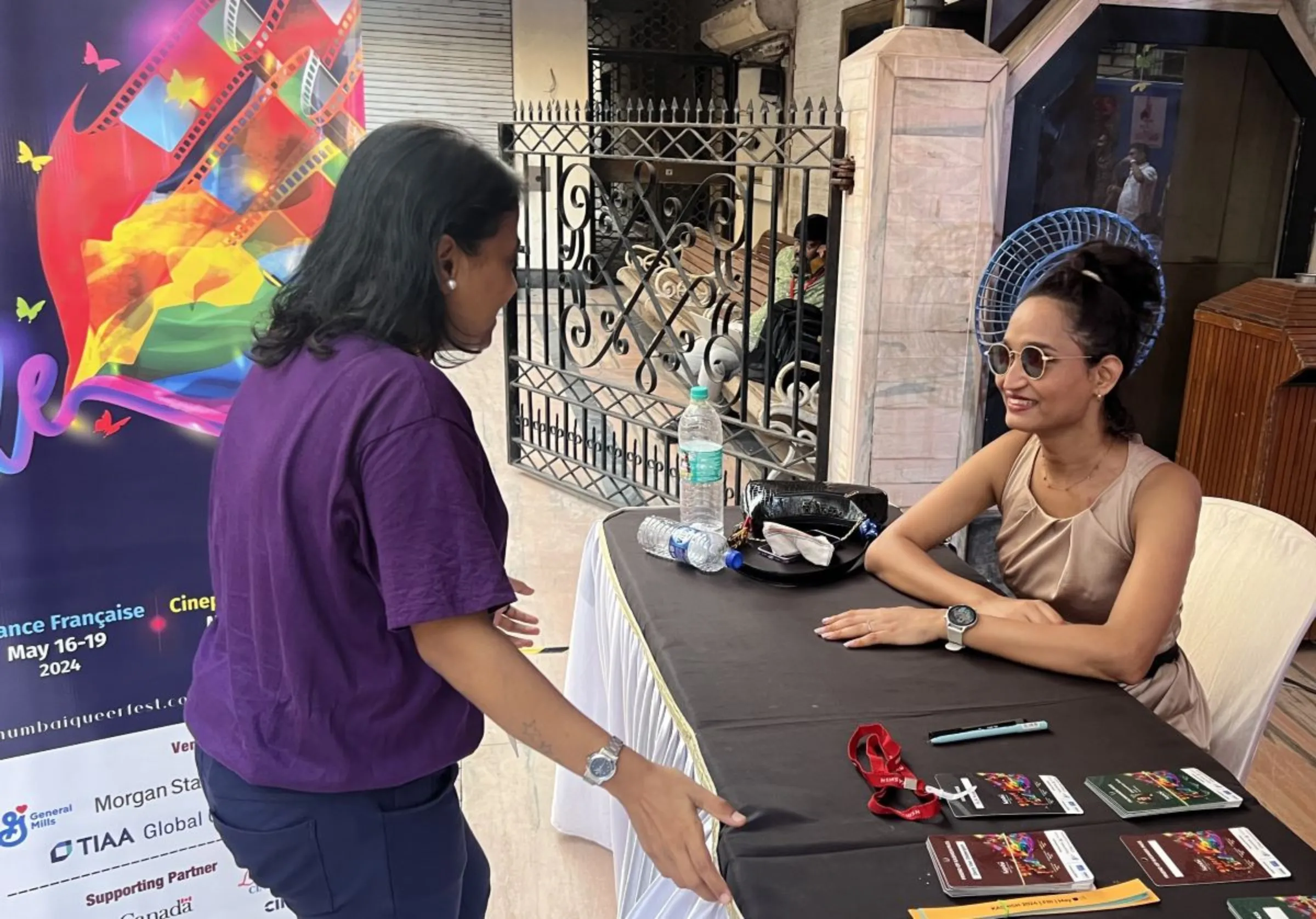 Transgender activist Anjali Siroya speaks to a woman at the information centre for a queer film festival in Mumbai, Maharashtra, May 2024. Thomson Reuters Foundation / Aniket Narawad