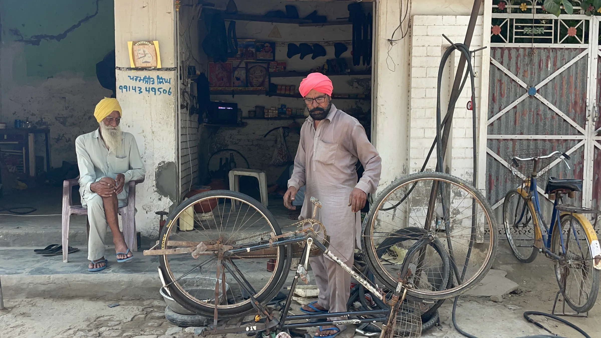 Paramjit Singh, a mechanic, who borrowed 900,000 rupees to send his son to Italy on a seasonal work permit, repairs a bicycle in Chand Nawan village of Punjab, India, September 24, 2024. Thomson Reuters Foundation/Sandeep Singh