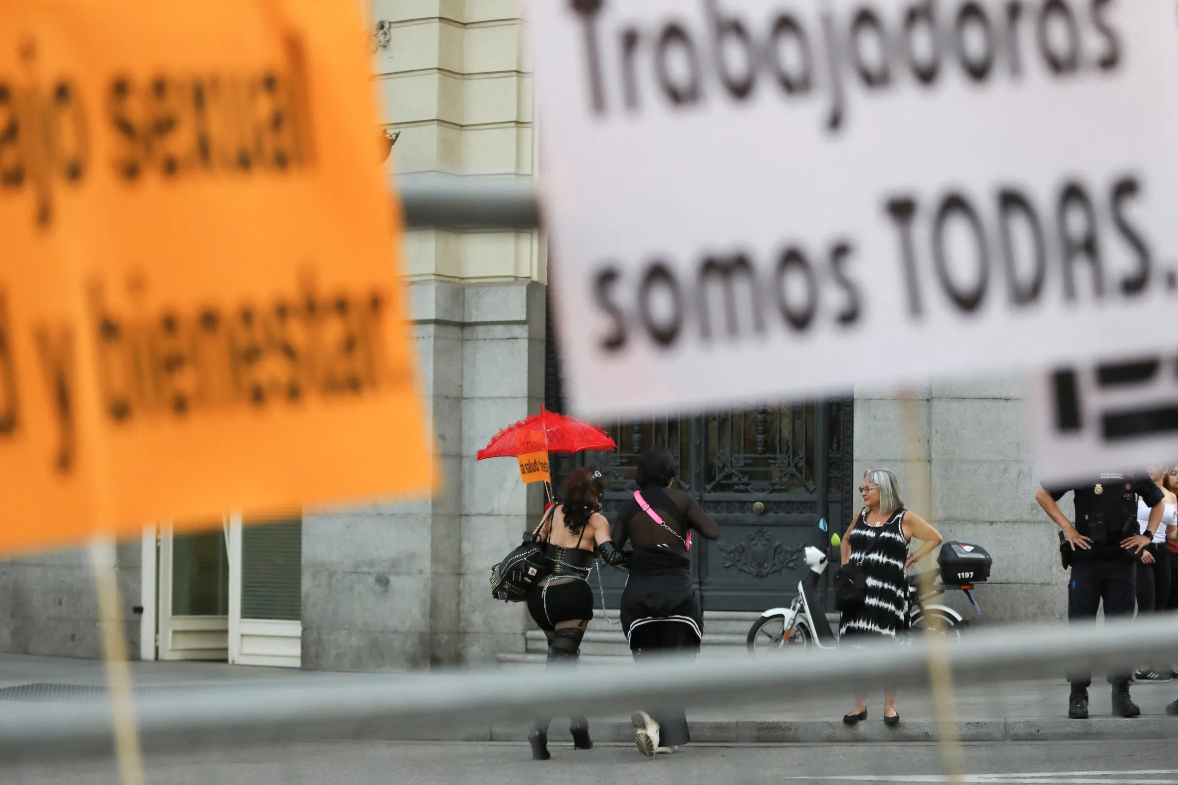 A sign reading 'We are all workers' is pictured on a fence as protesters leave a demonstration against the proposed law to abolish sex work in the country, in Madrid, Spain, October 4, 2022