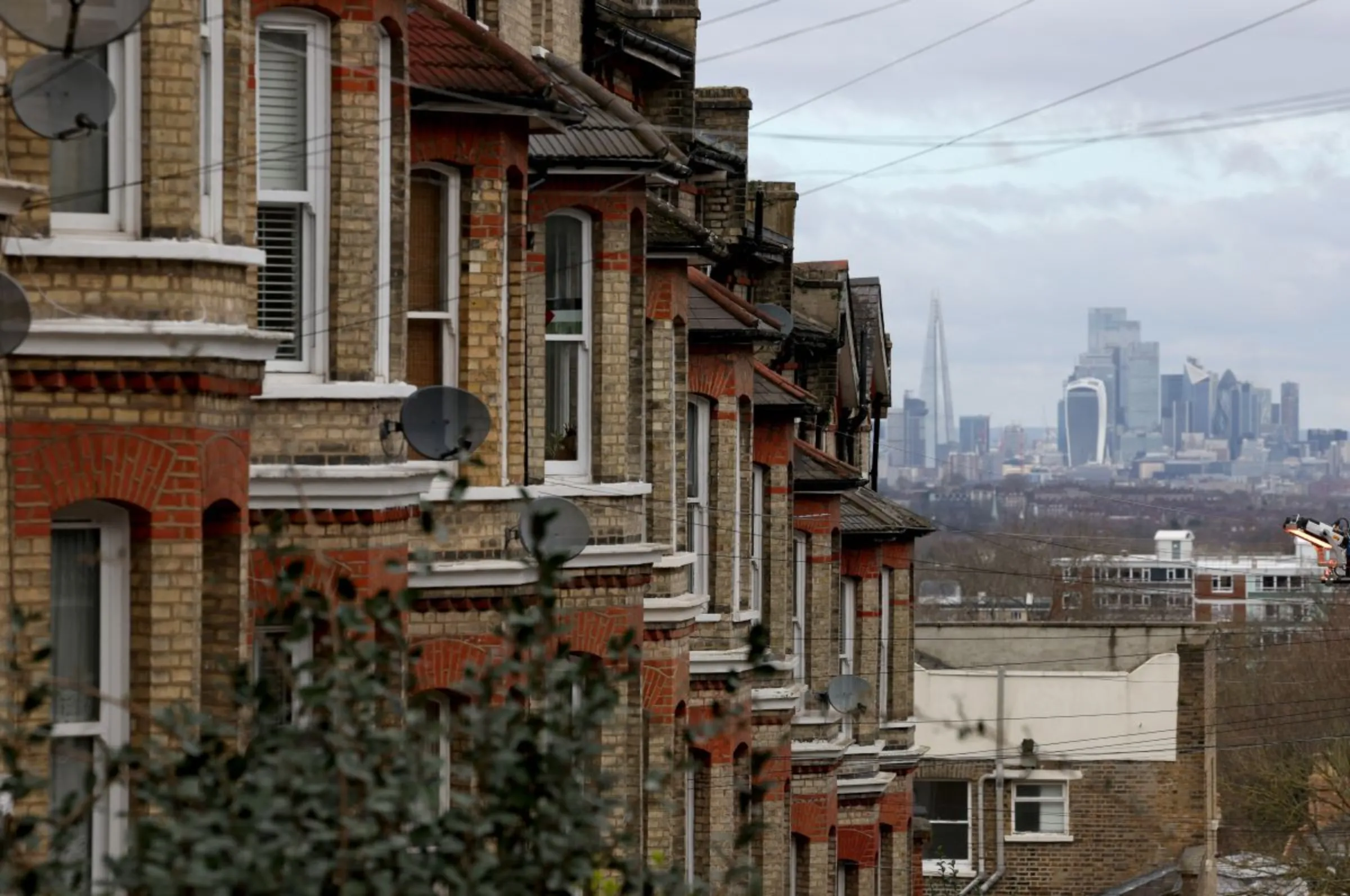 A row of residential houses is seen with the financial district in the distance in South London, Britain, February 26, 2024. REUTERS/Hannah McKay