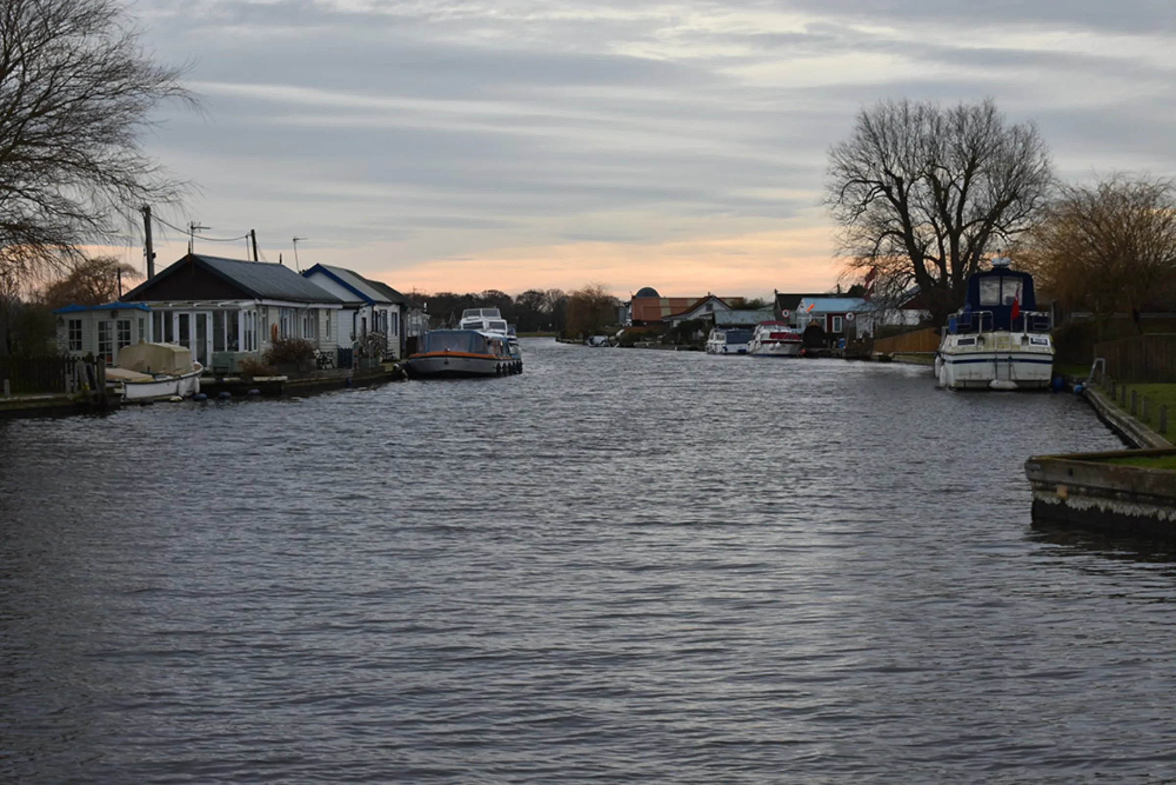 Homes and boats on the River Thurne in the village of Potter Heigham in the Broads, east England, February 10, 2023. Thousands of fish died in this stretch the Thurne in the saline incursion in September 2022. Thomson Reuters Foundation/Rachel Parsons