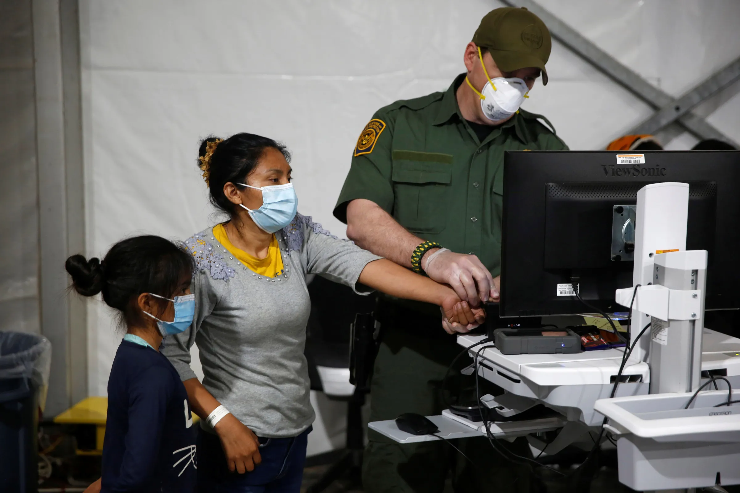 A migrant and her daughter have their biometric data entered at the Homeland Security holding facility in Rio Grande Valley, in Donna, Texas. Dario Lopez-Mills/Pool via REUTERS