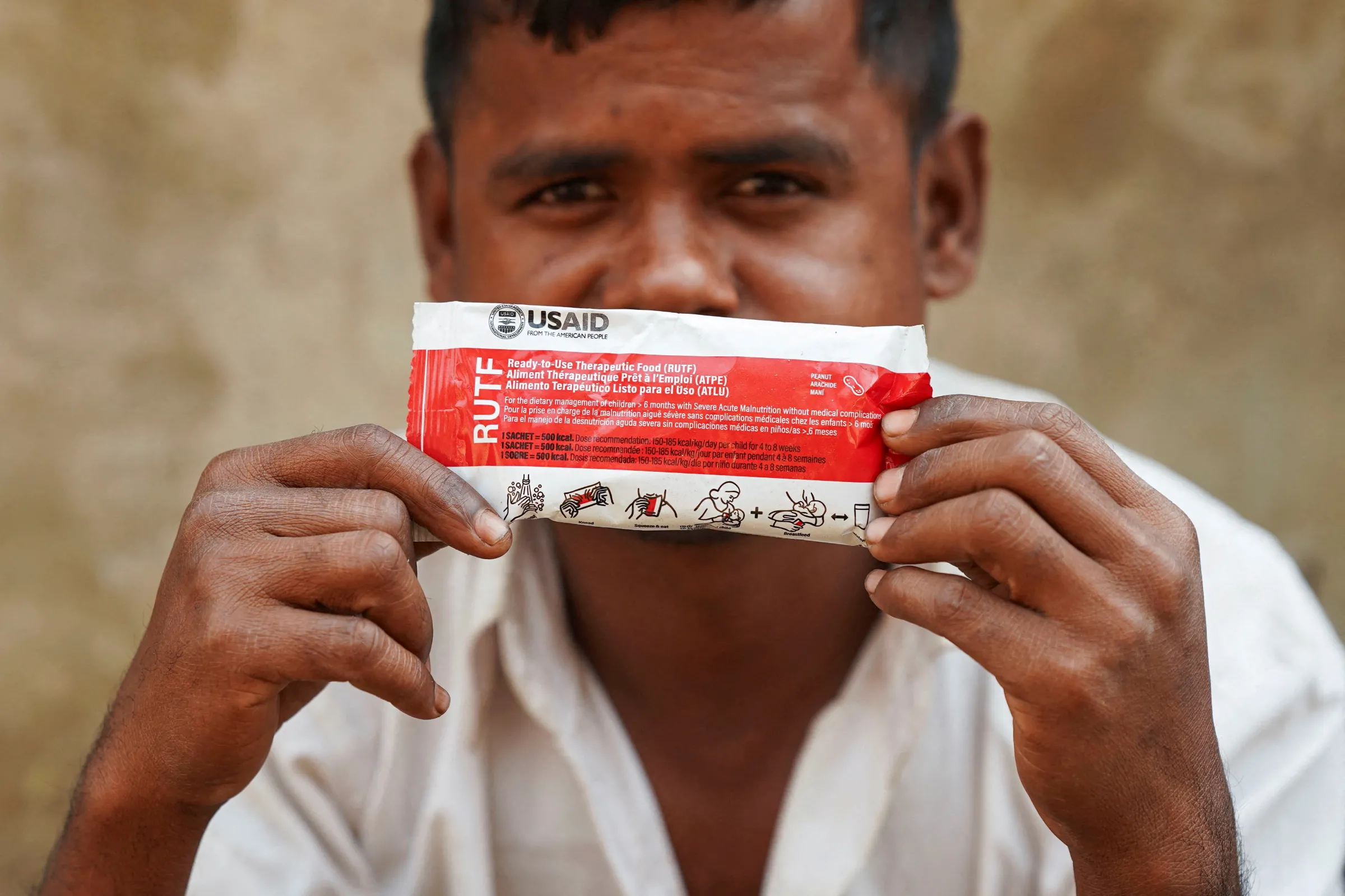 A Rohingya man poses for a picture with a nutrition supplement packet provided by USAID among Rohingya refugees, in Cox's Bazar, Bangladesh, February 5, 2025. REUTERS/Ro Yassin Abdumonab