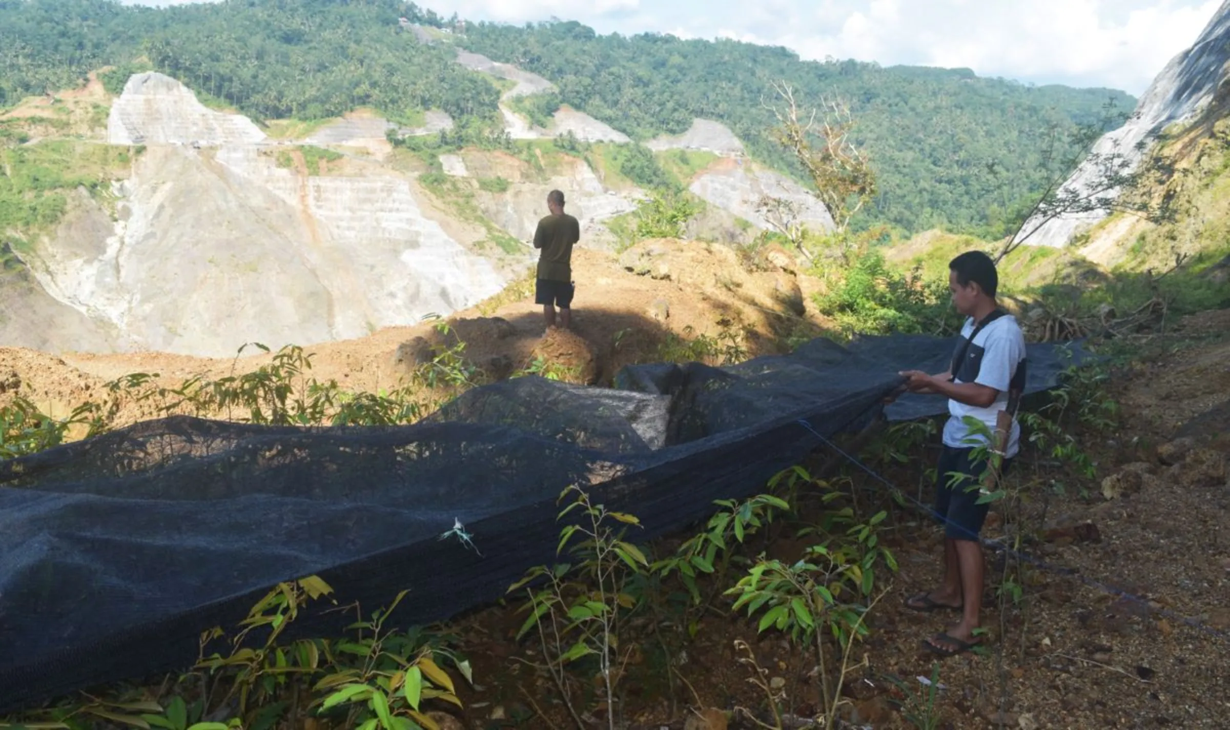Gunawan installing nets to protect the plant seeds on his land which had been eroded by the Bener Dam project in Guntur, Purworejo Regency, Indonesia, December 18, 2022. Thomson Reuters Foundation/Asad Asnawi.