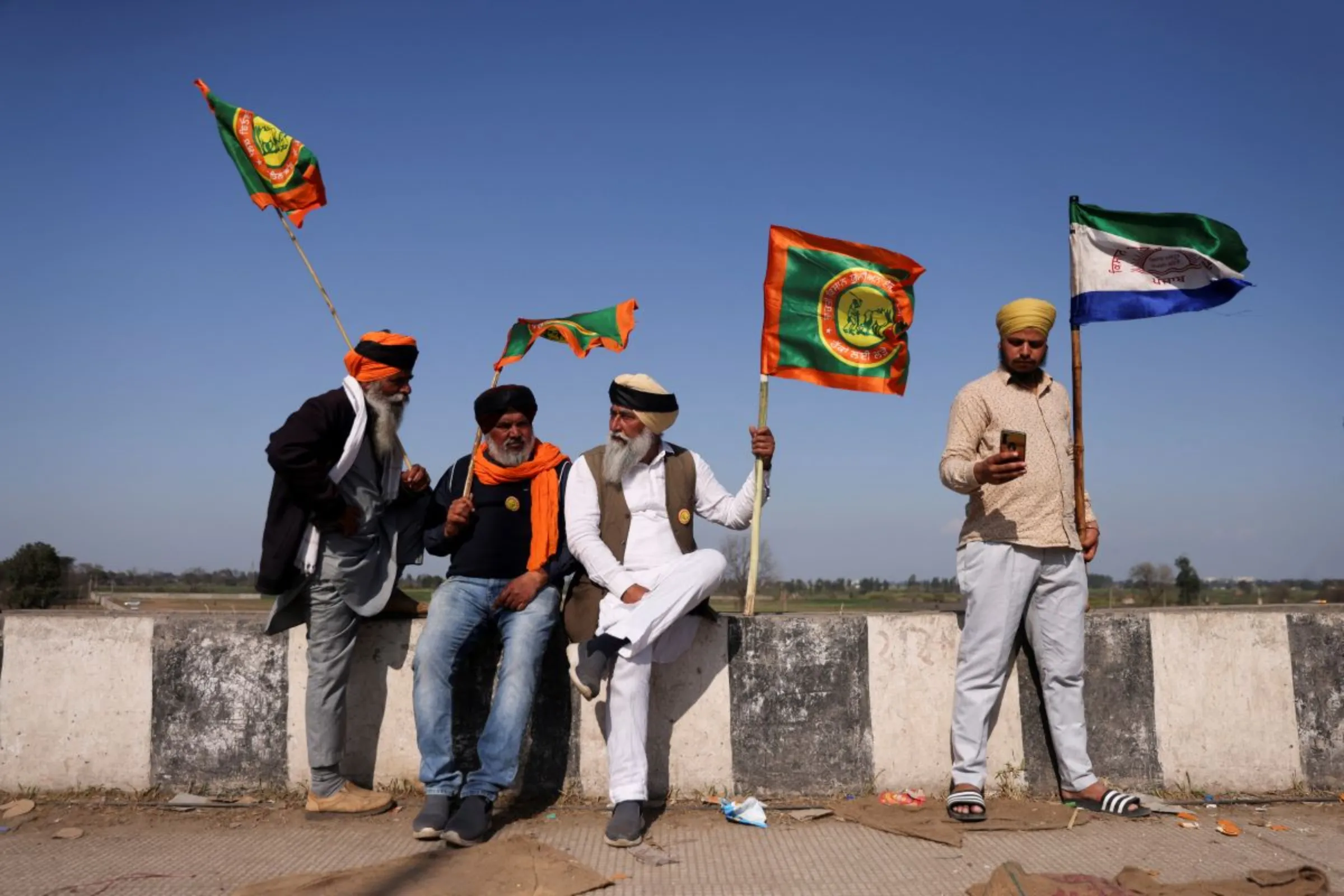 Farmers hold flags at a protest site, during the march towards New Delhi to push for better crop prices promised to them in 2021, at Shambhu Barrier, the border between Punjab and Haryana states, India February 23, 2024. REUTERS/Francis Mascarenhas