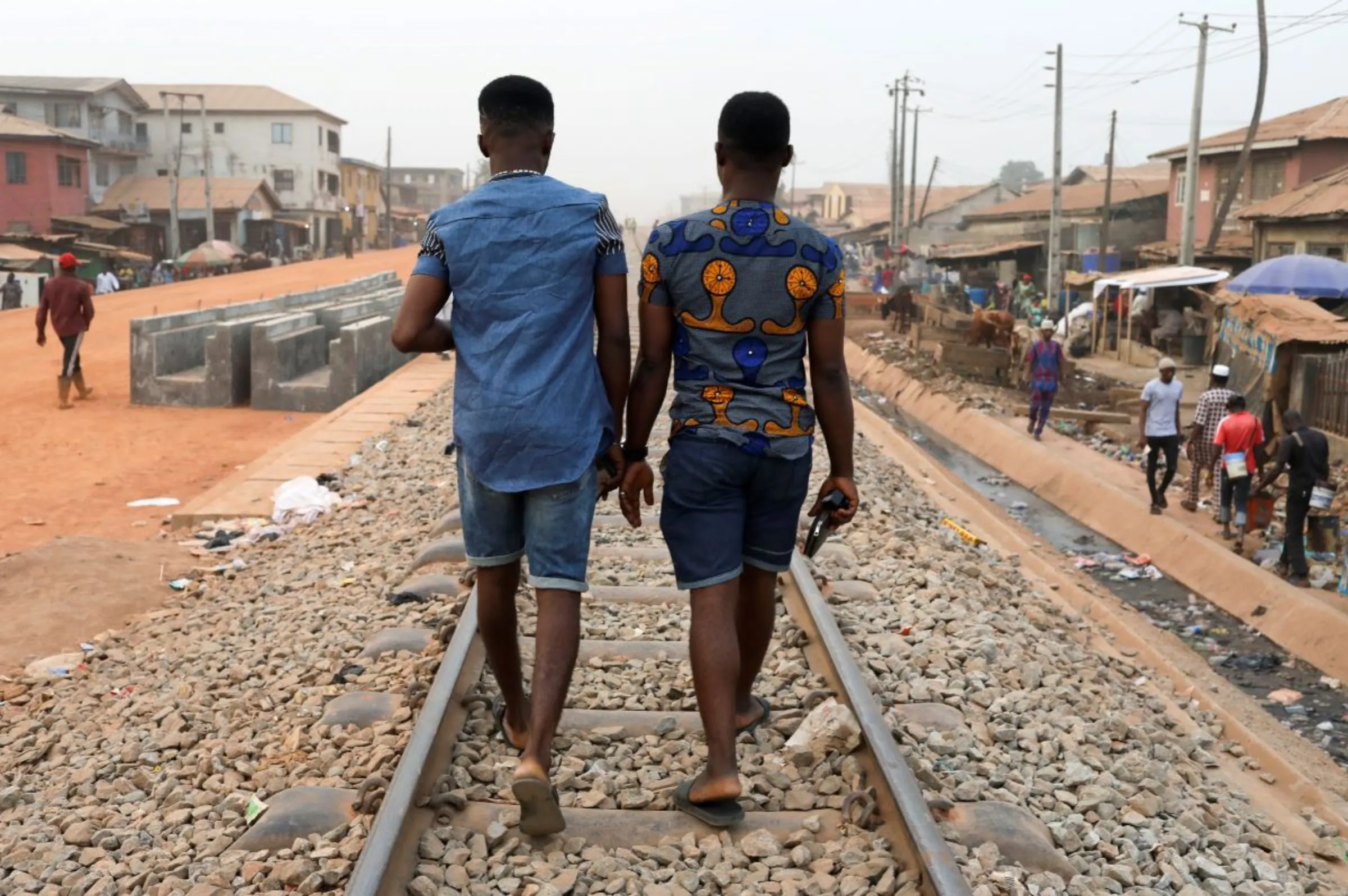 Chris Agiriga (left), 23, one of the Nigerian men arrested on charges of public display of affection with members of the same sex, walks with a friend on the streets of Mushin in Lagos, Nigeria, February 14, 2020. REUTERS/Temilade Adelaja