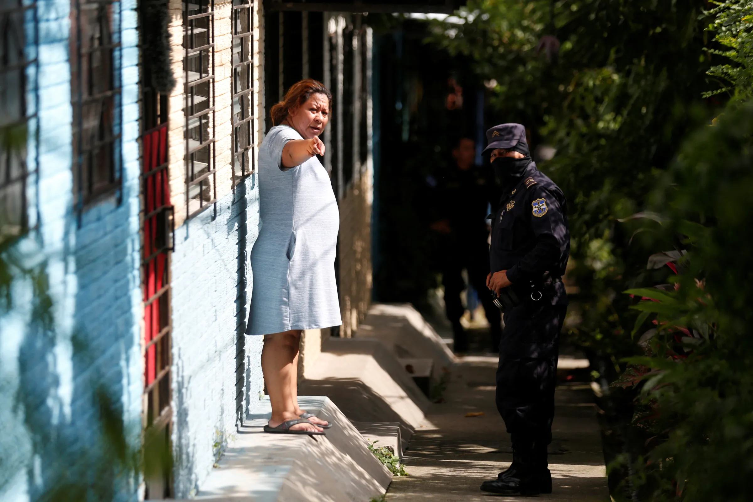 Police officer talks with a woman during a "Casa Segura" (Safe House) operation as part of the state of emergency to fight gangs
