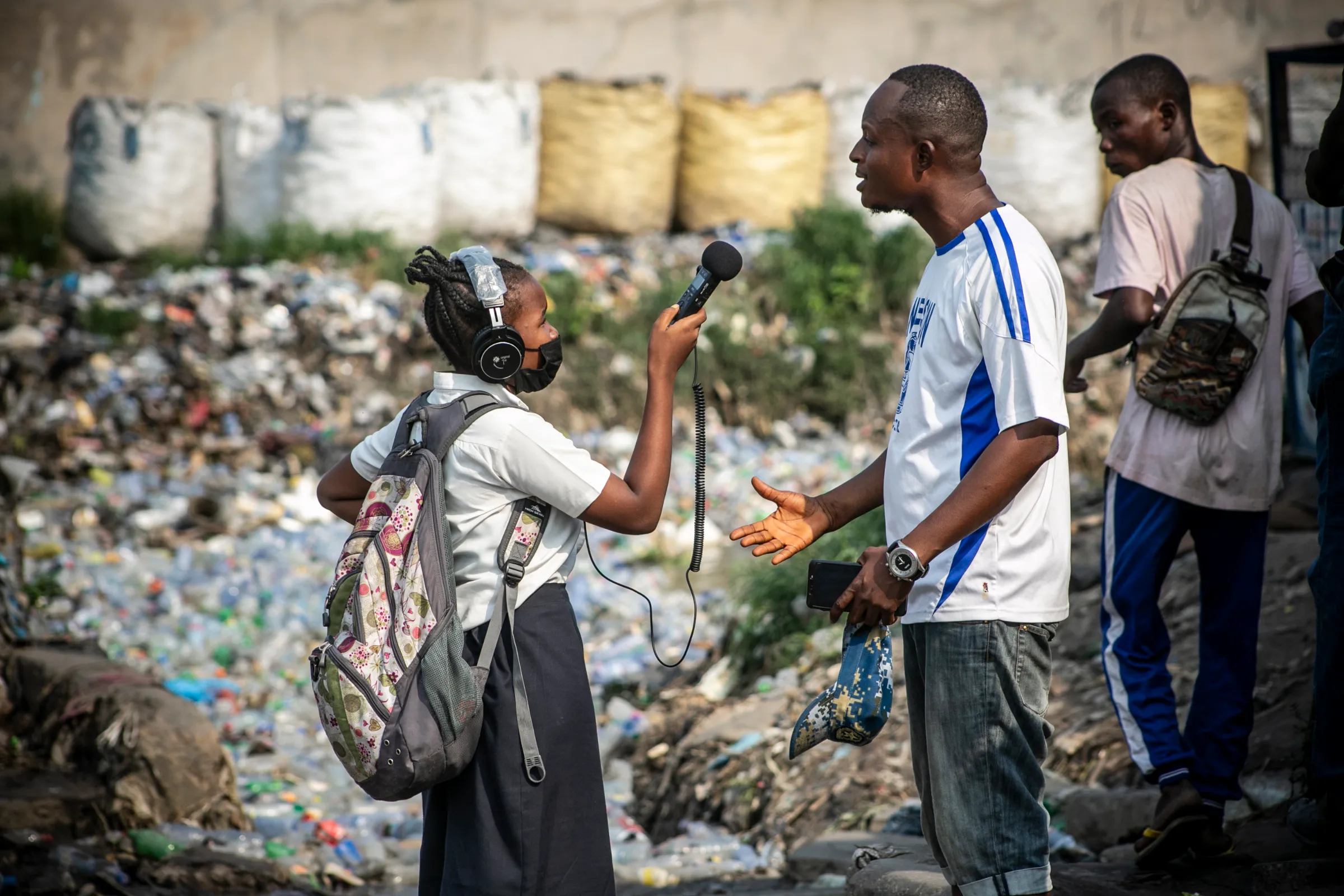 Emilie Zikudieka, a young reporter from the Children’s Radio Foundation, interviews a resident of Kalamu on the plastic waste in the rivers in Kinshasa, The Democratic Republic of Congo, March 3, 2021. Ley Uwera/Handout via Thomson Reuters Foundation