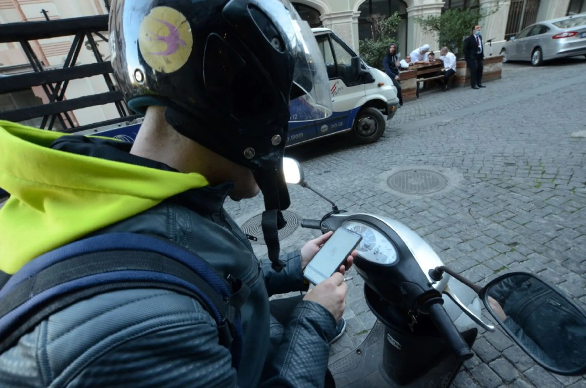 Georgian delivery driver Andro, 30, who works for Spanish company Glovo, sits on his moped in Tbilisi, Georgia. October 19, 2021