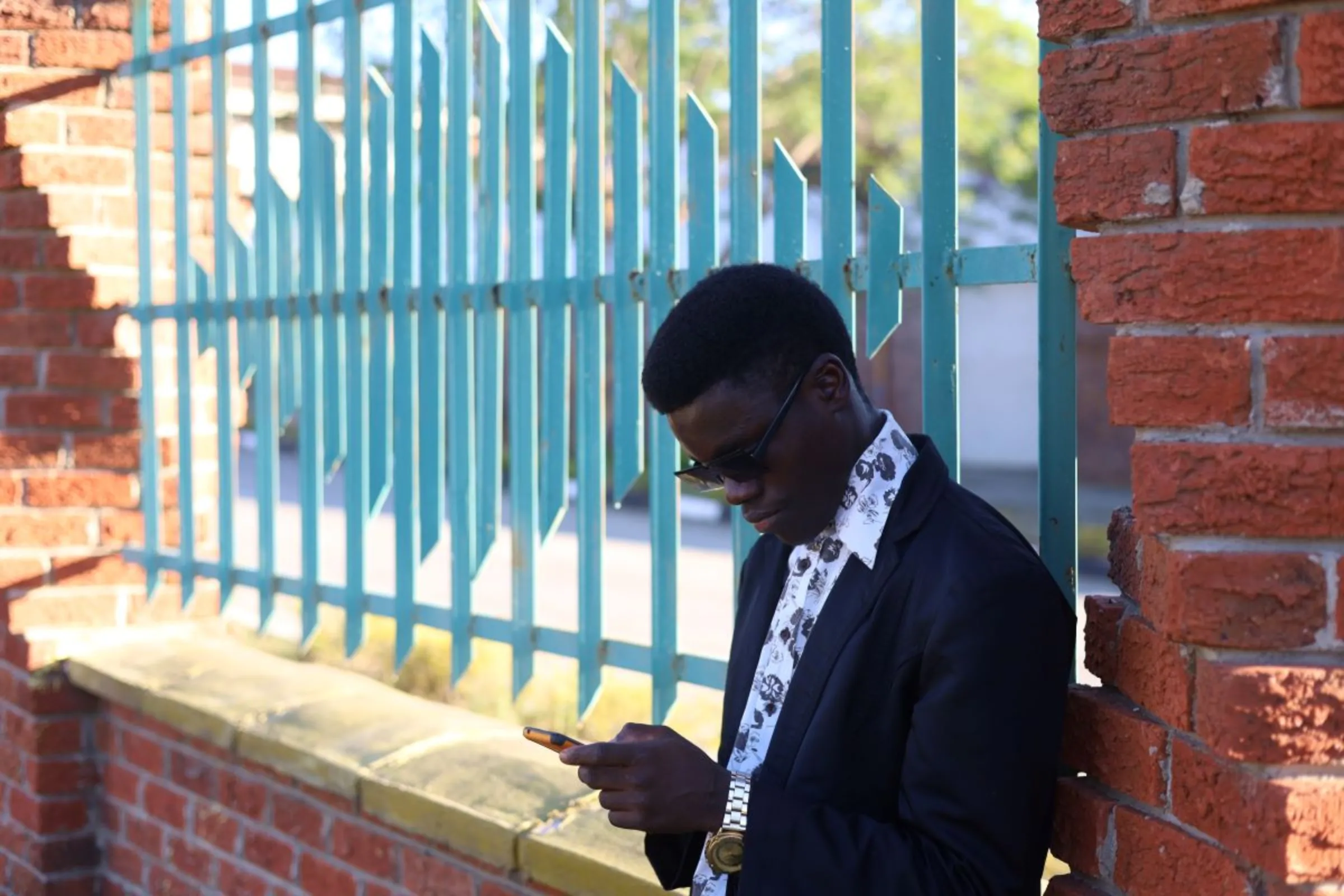 A Zimbabwean student stands outside a building to use its Wifi connection in Mutare, Zimbabwe, November 5, 2023. Thomson Reuters Foundation/Farai Shawn Matiashe