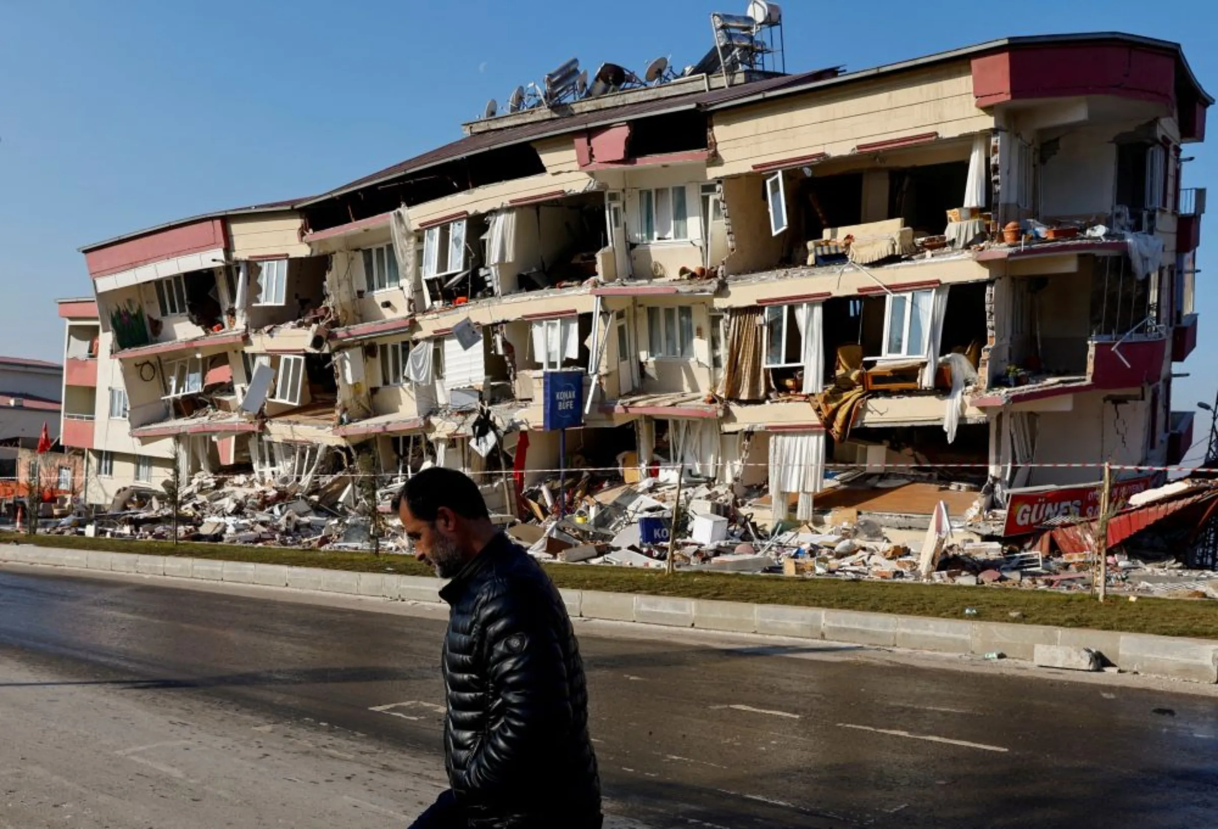 A man walks past a damaged building in the aftermath of a deadly earthquake in Kahramanmaras, Turkey February 13, 2023