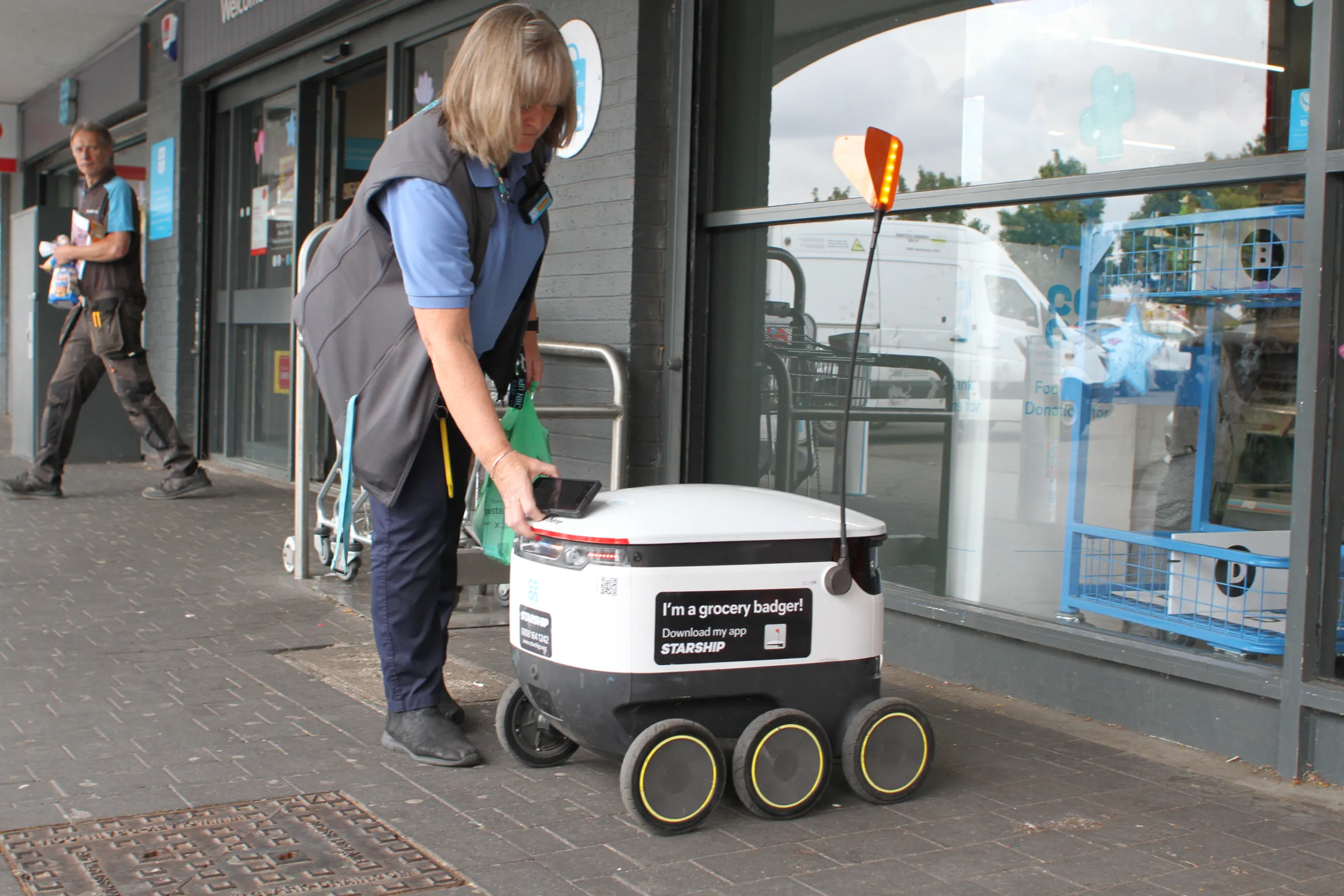 A store worker loads up a Starship Technologies delivery robot with groceries outside a supermarket in Bedford, Britain, on September 15, 2022. THOMSON REUTERS FOUNDATION/Lin Taylor