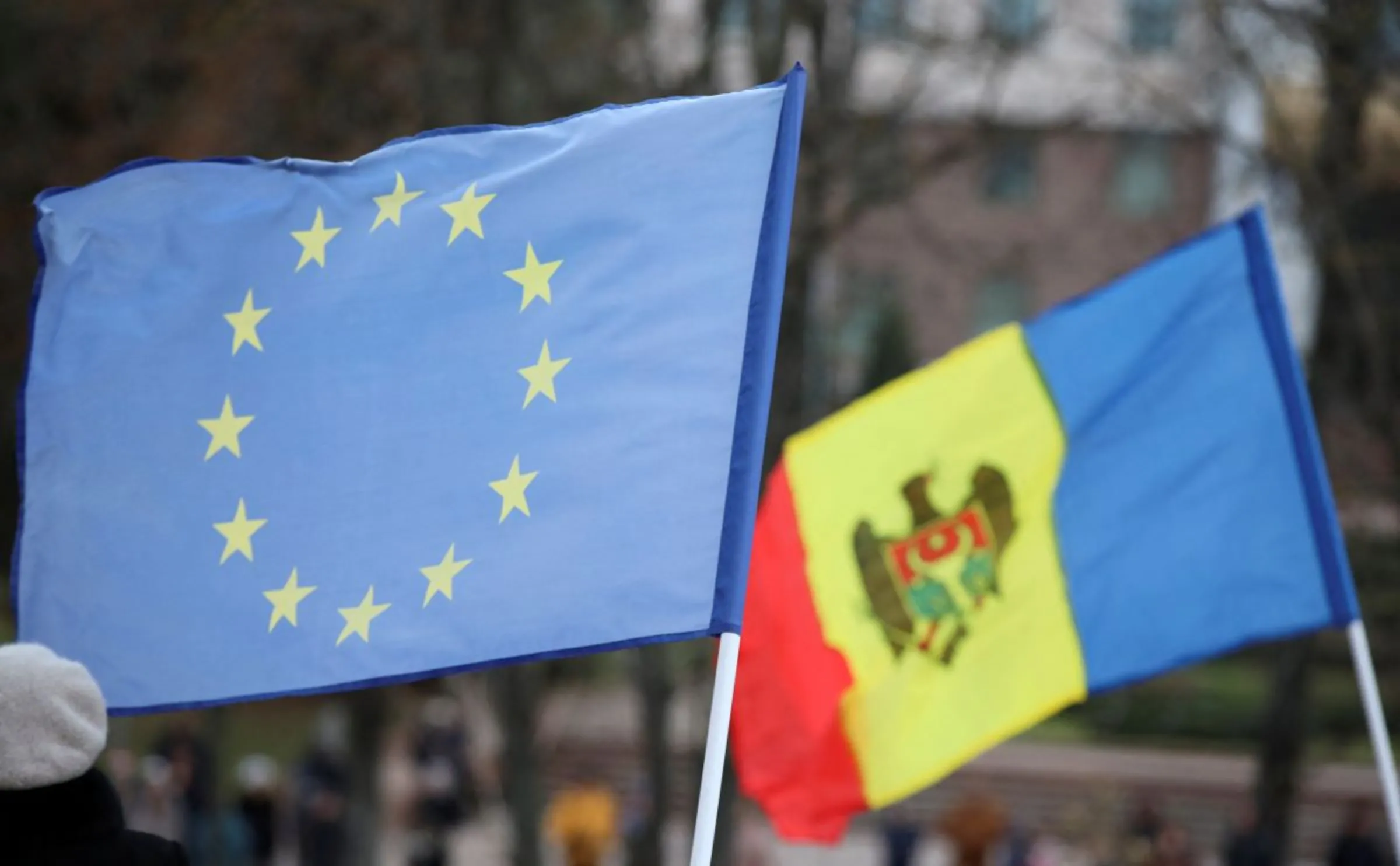 Participants hold flags during a rally and concert celebrating the European Union's decision to open membership talks with Moldova, in Chisinau, Moldova, December 17, 2023. REUTERS/Vladislav Culiomza