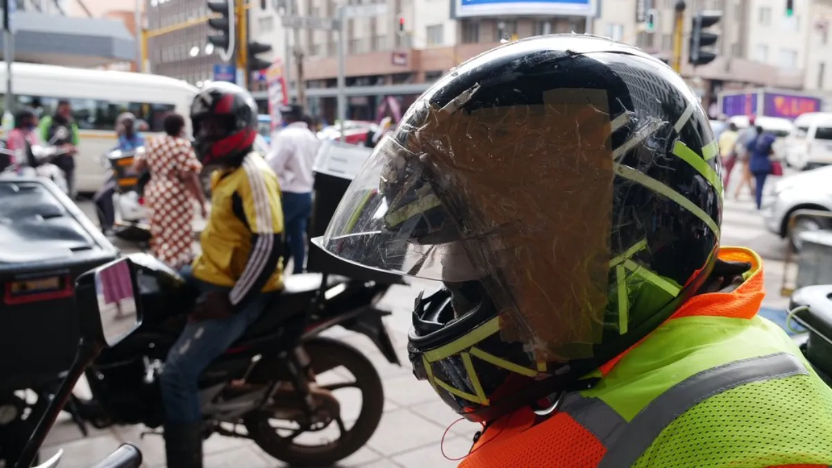 John's smashed helmet has been taped together with duct tape as he cannot afford a new one, and most food courier companies do not provide them for their drivers. Pretoria, South Africa. February 9, 2020. Thomson Reuters Foundation/Kim Harrisberg