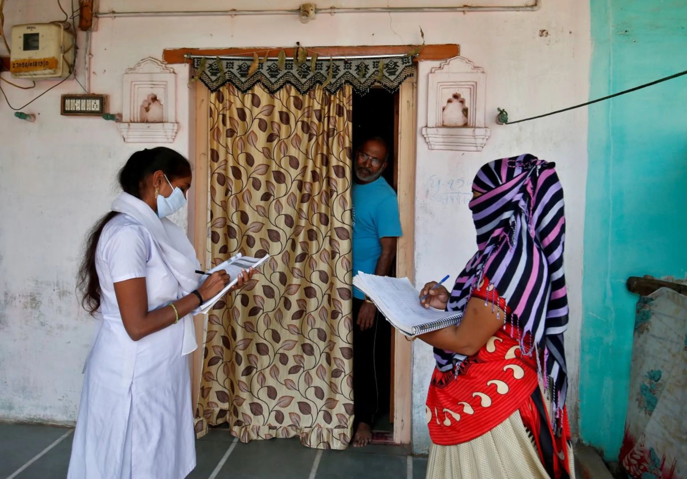 Health workers collect personal data during a door-to-door survey for the first shot of COVID-19 vaccine, in a village on the outskirts of Ahmedabad, India, December 14, 2020