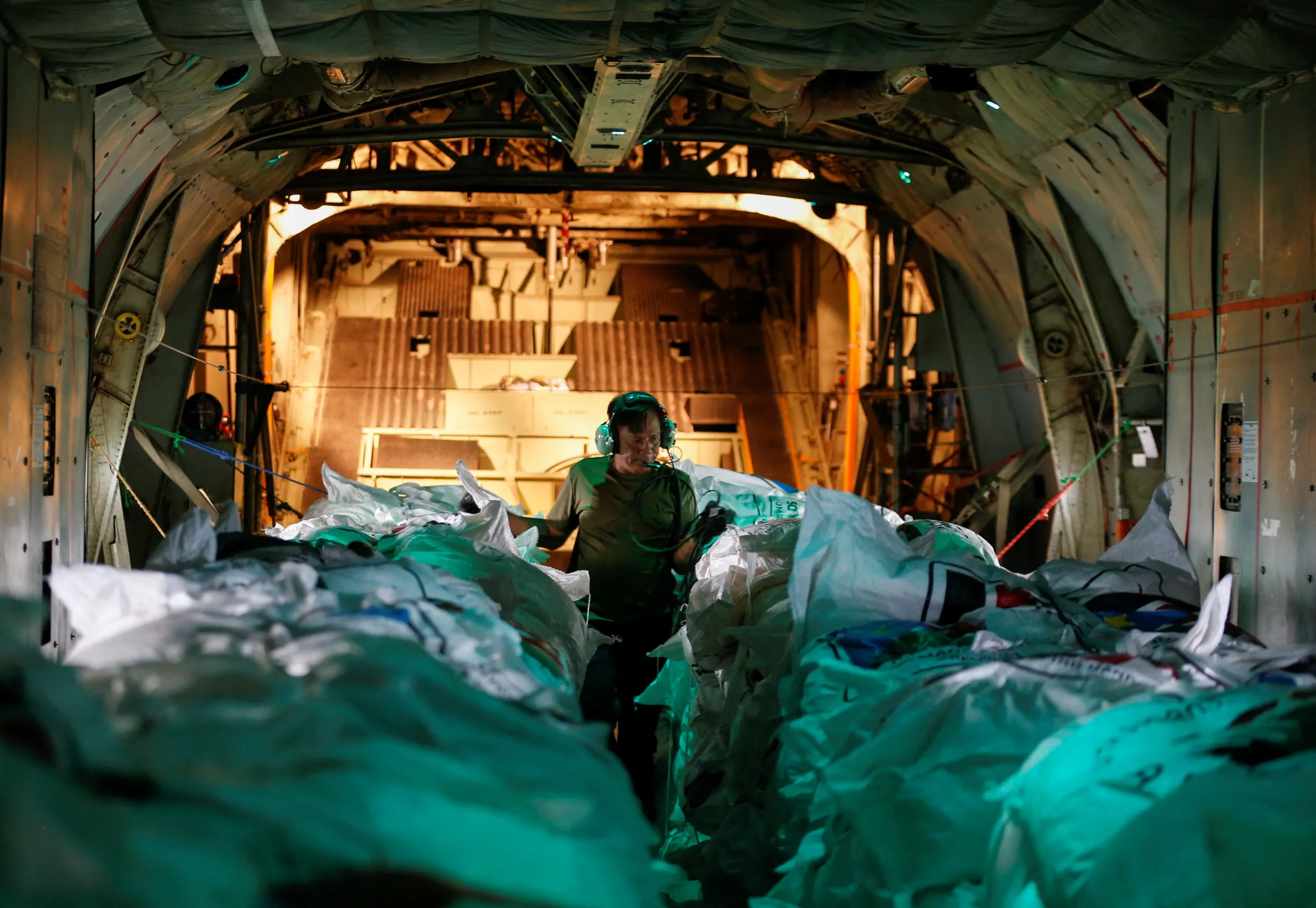 A worker prepares to release food from a cargo plane in Nasir County, South Sudan, in an operation run by U.S. company Fogbow. June 10, 2025. REUTERS/Thomas Mukoya