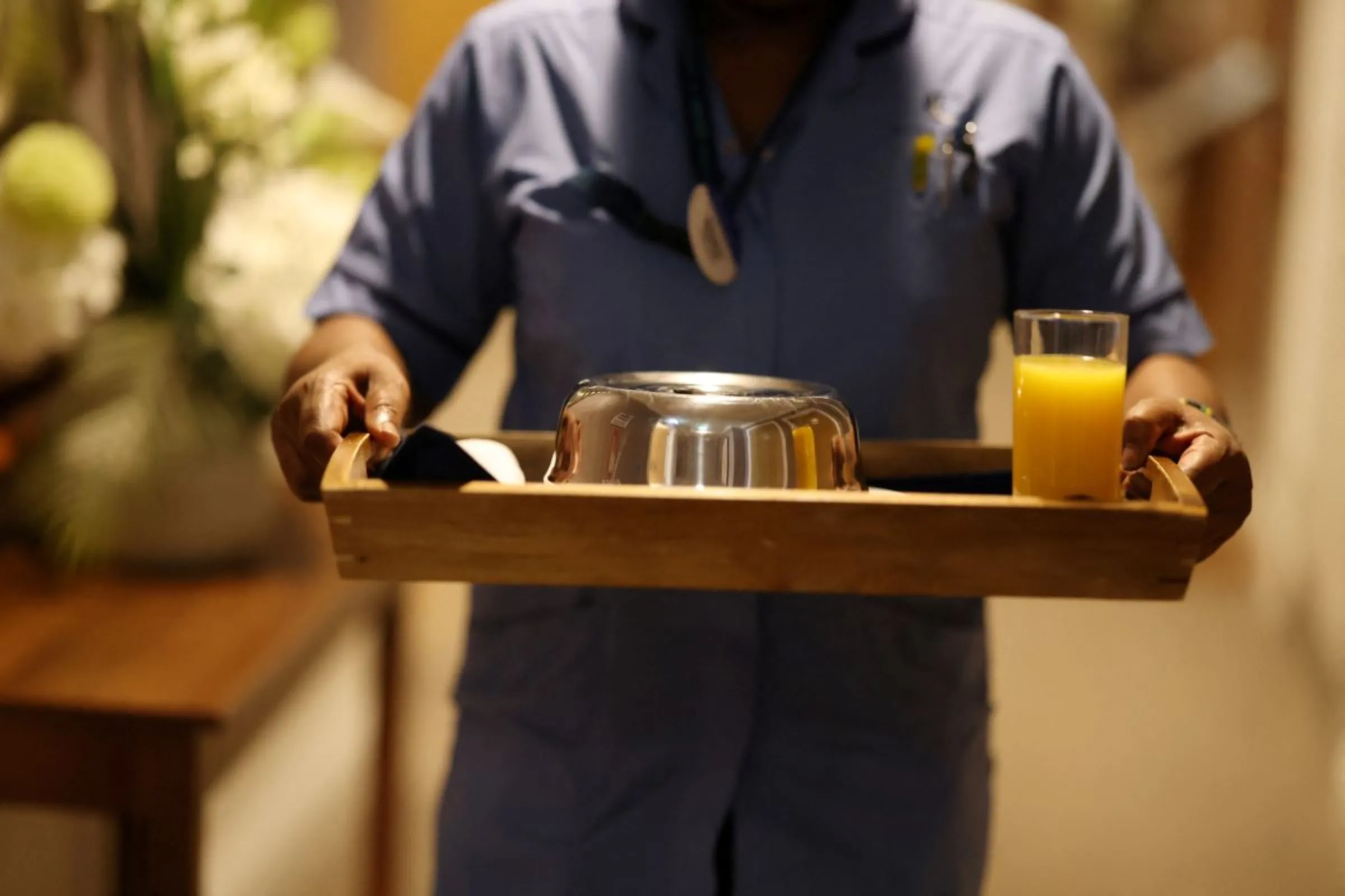 A care home worker carries a meal to a room at Rokewood Court Care Home in Kenley, Britain, July 29, 2023. REUTERS/Hollie Adams