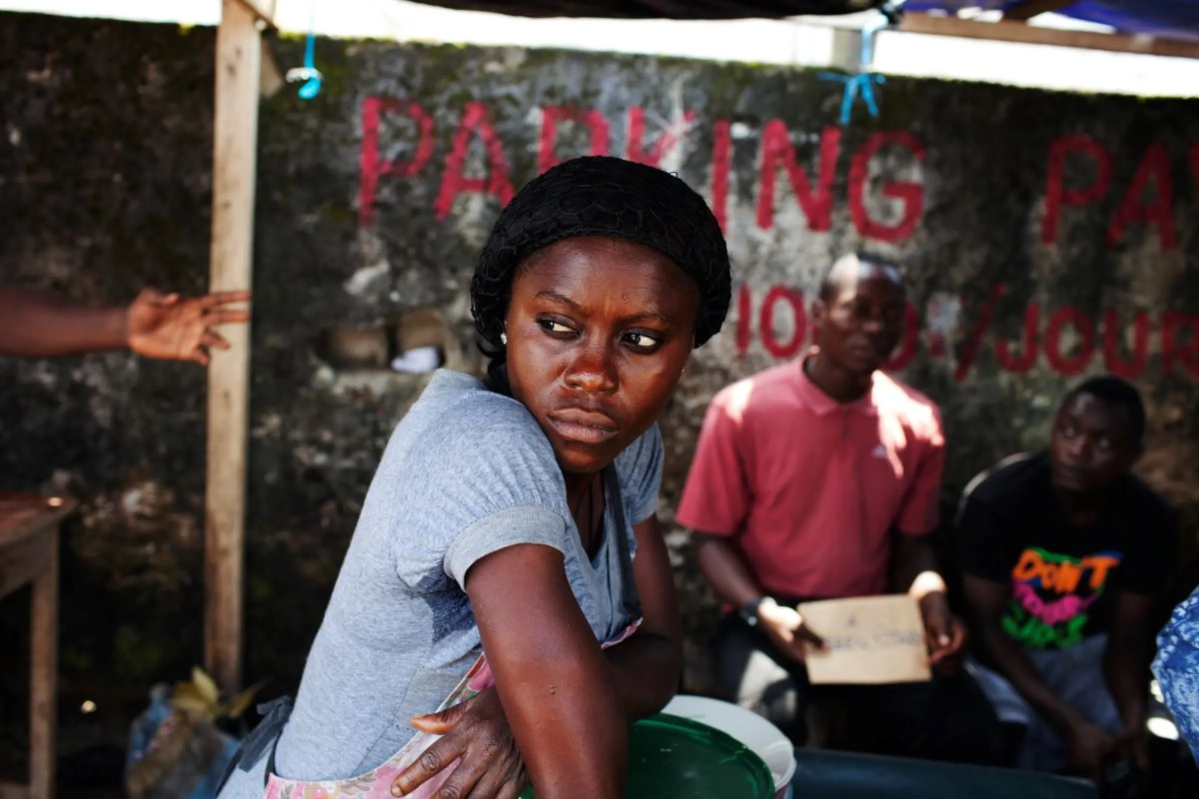 A woman selling food at a stall gazes at people at the bus station she works at in Douala November 4, 2013. REUTERS/Joe Penney