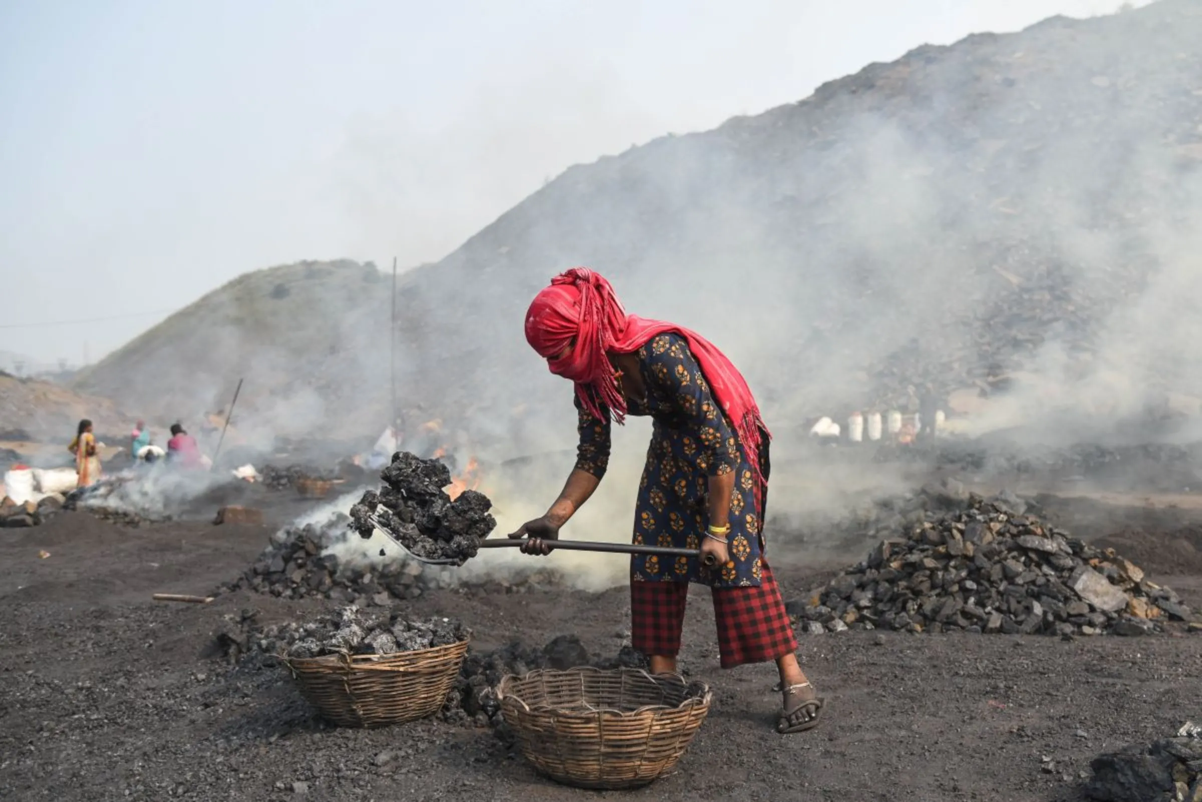 A child coal scavenger burns coal before selling it for use at a depot in a mining area of Jharia coalfield, India, November 11, 2022. Thomson Reuters Foundation/Tanmoy Bhaduri