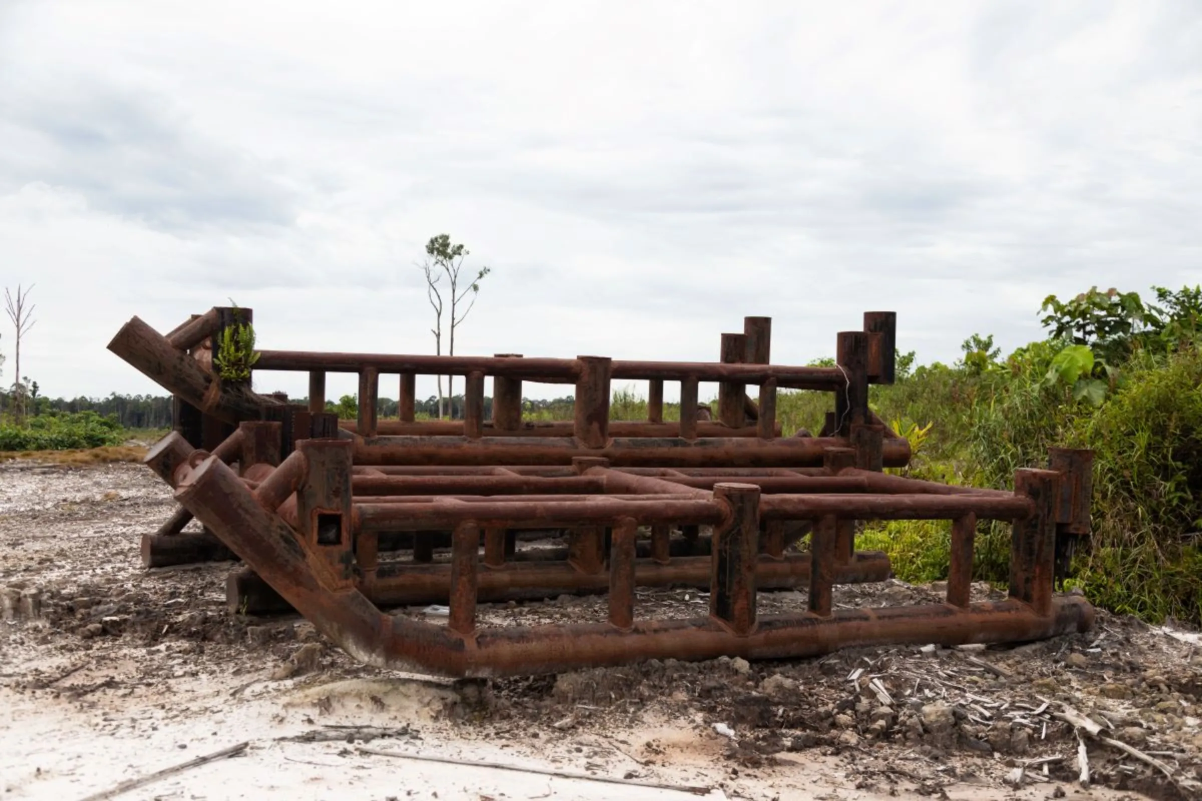 An abandoned rusty machine structure in the food estate zone in Central Kalimantan, Indonesia June 20, 2023. The central government initiated a food security program in 2020 to grow cassava in this area but the project has stopped. Thomson Reuters Foundation/Irene Barlian