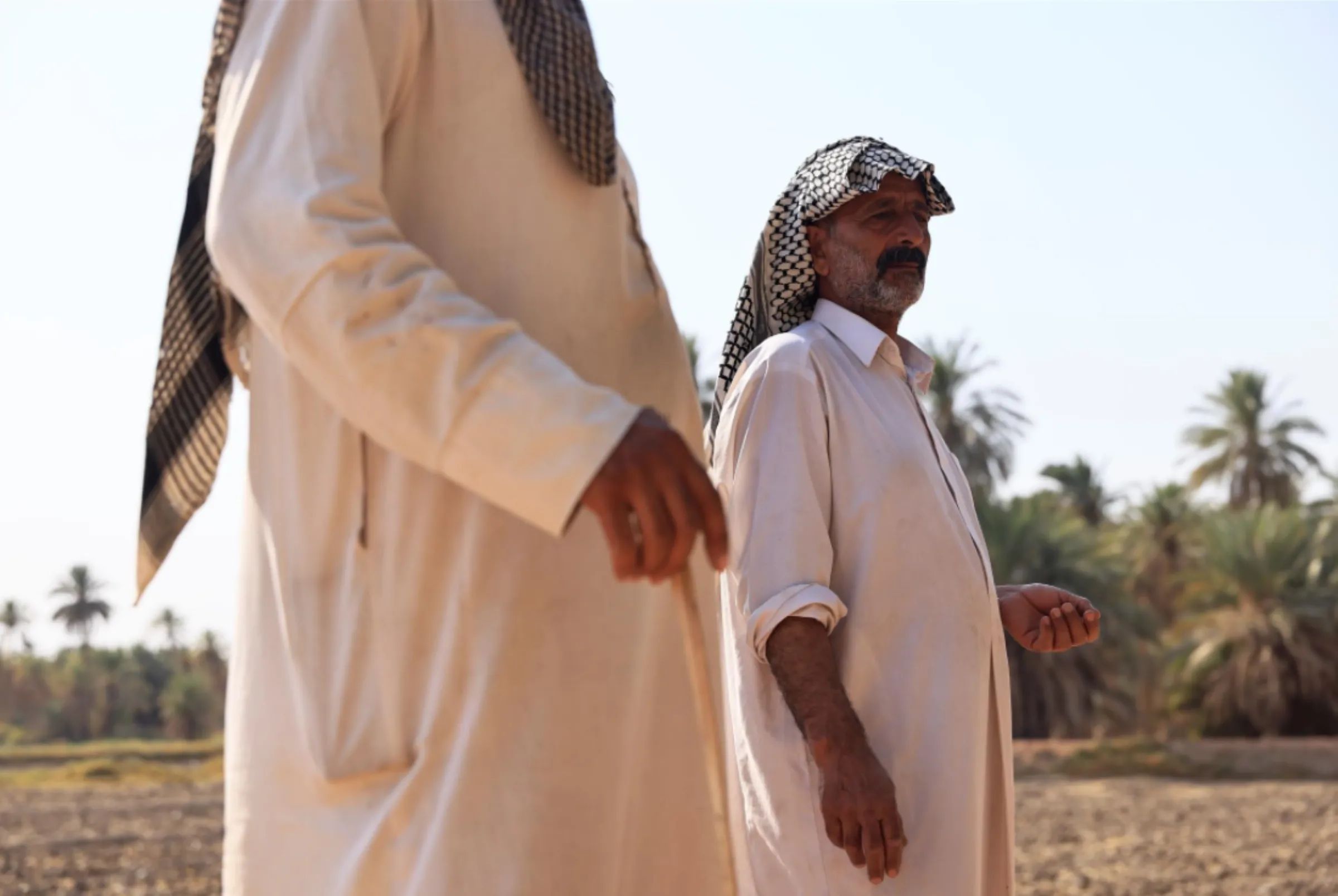 Abed al-Hussein Kusayr stands with his son by his farm in al-Meshkhab district in Najaf, Iraq, October, 12, 2022