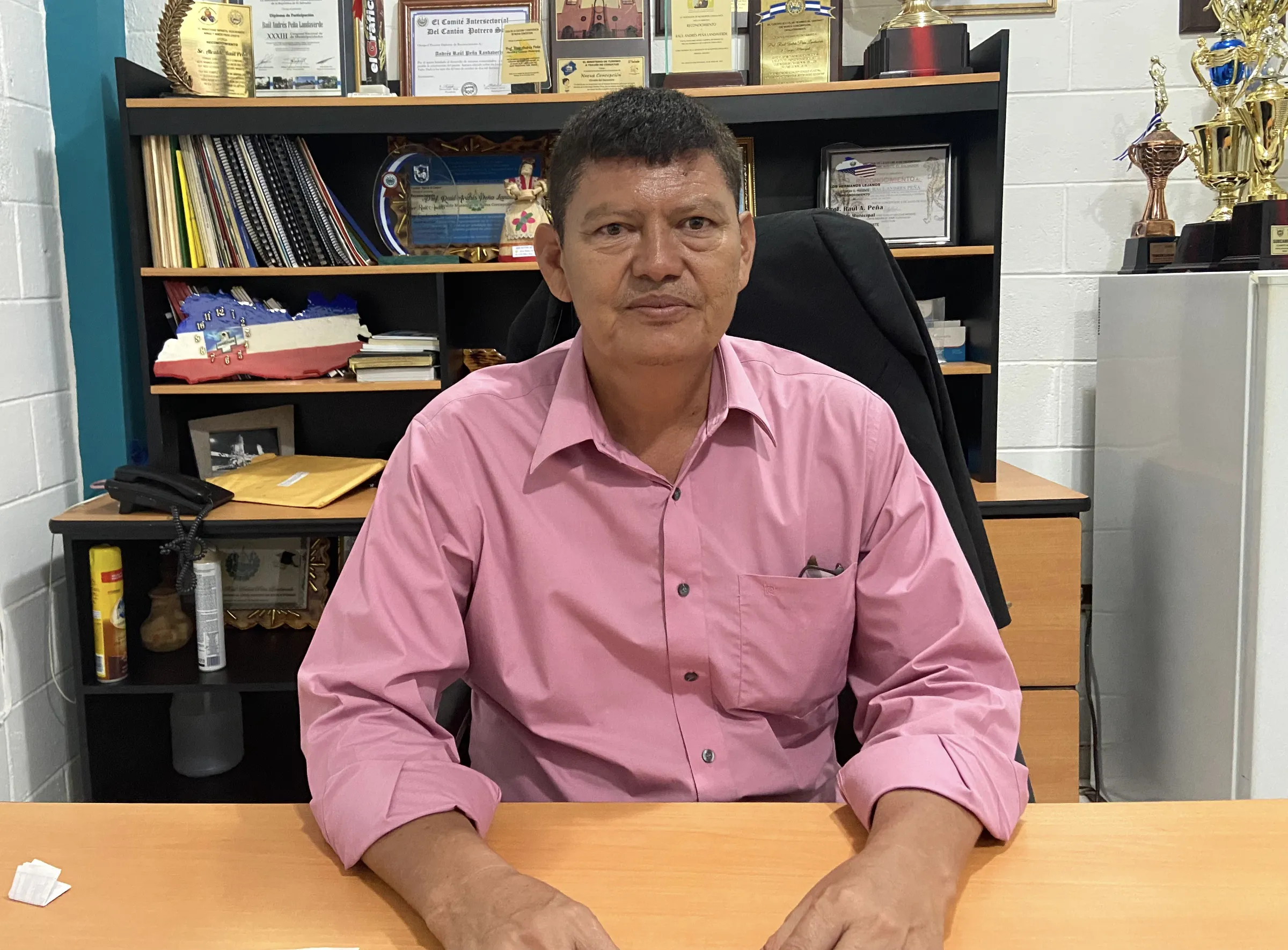 Raul Peña, the mayor of Nueva Concepción, El Salvador, poses for a photo sat at a desk in his office on Sept 9, 2022. Thomson Reuters Foundation/Anna-Catherine Brigida