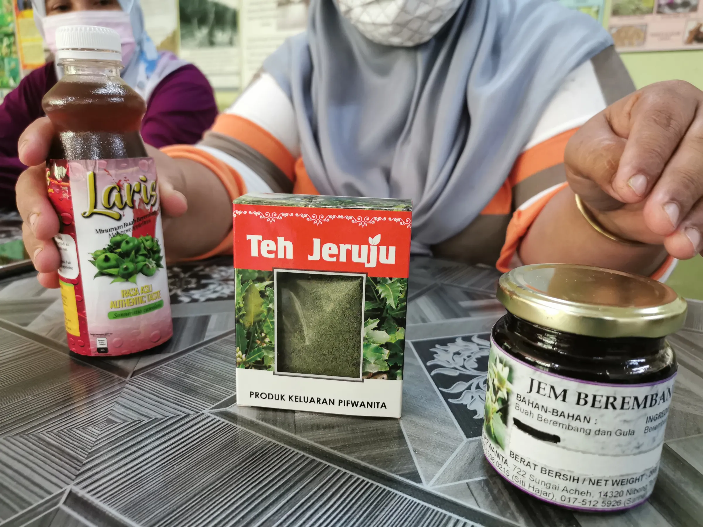 A Malaysian woman shows products made from mangroves including tea, juice and jam