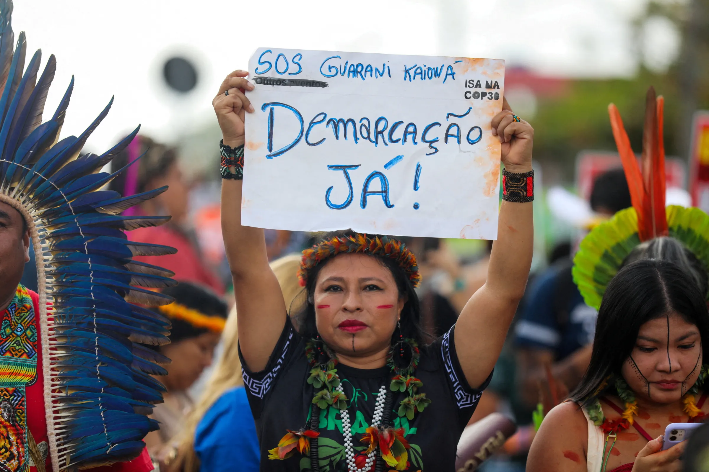 An indigenous woman holds a sign reading: 'Demarcation now!', during a protest to call for climate justice and territorial protection during the U.N. Climate Change Conference (COP30), in Belem, Brazil, November 17, 2025. REUTERS/Anderson Coelho
