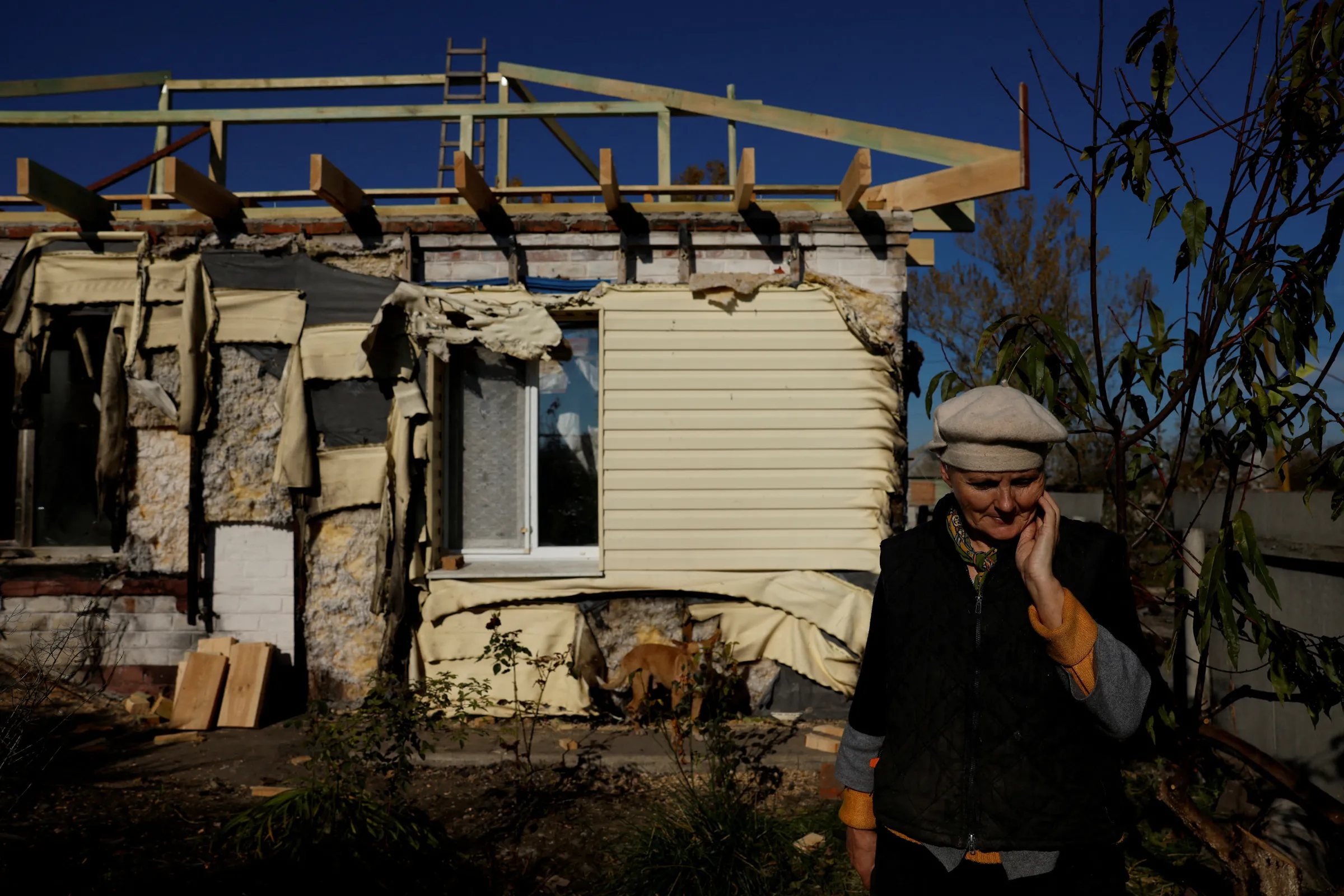 A women stands outside her home that was destroyed by a Russian grad rocket, which she is now trying to repair, after extensive damage by Russian strikes also cut electricity and gas in the whole village, amid Russia's attack on Ukraine, in Korobochkyne, Ukraine, October 17, 2022