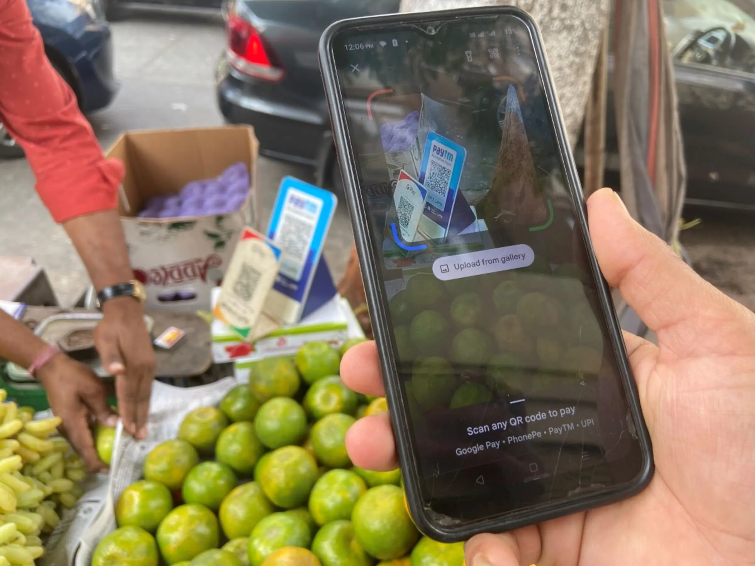 A customer scans a Quick Response (QR) code of India’s digital payments firm PayTM at a fruit stall in Mumbai, India, March 2, 2023. Thomson Reuters Foundation/Roli Srivastava