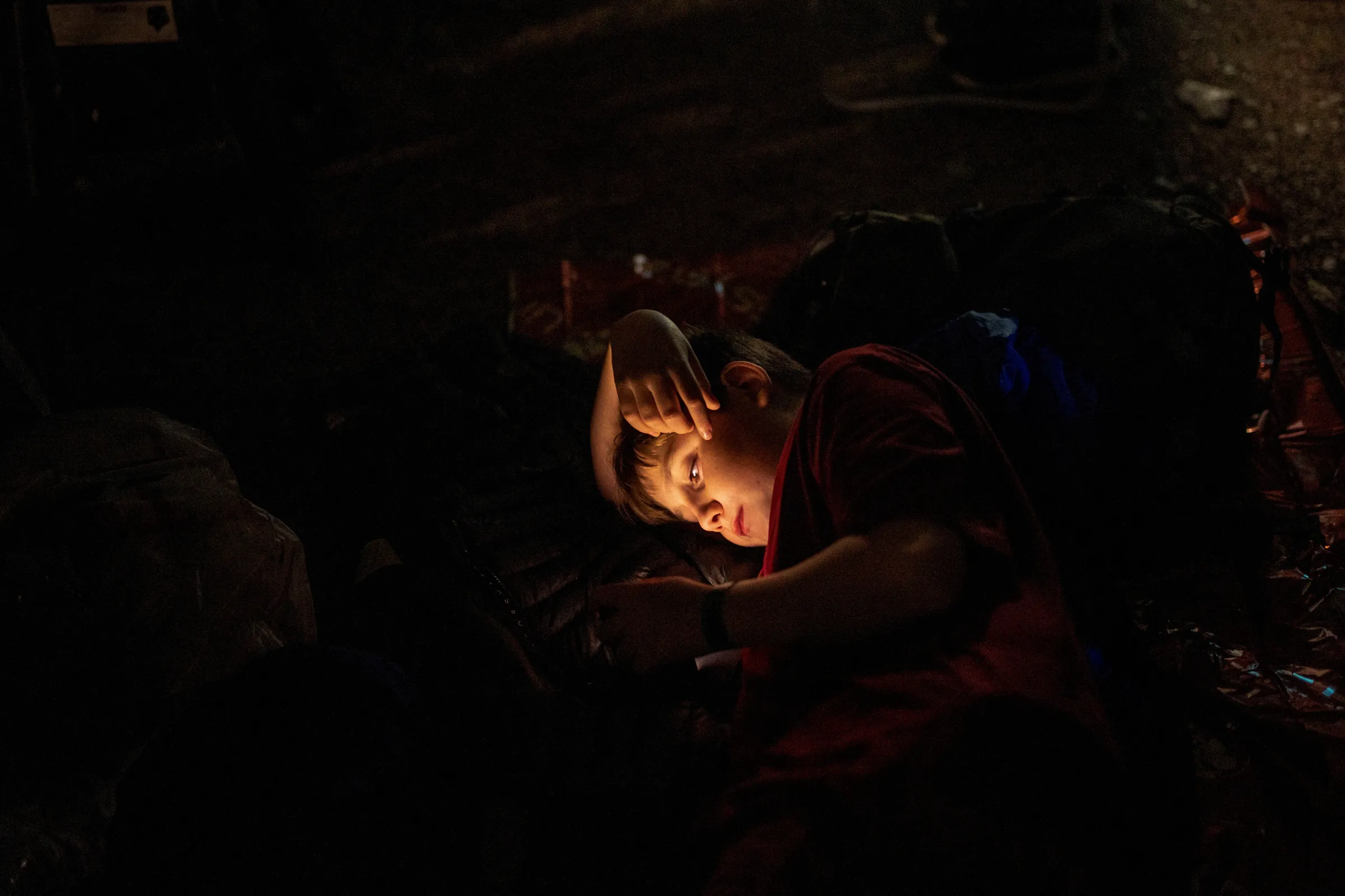 A child looks at his mobile phone as people camp a day before the funeral of Britain's Queen Elizabeth, following her death, in London, Britain September 18, 2022