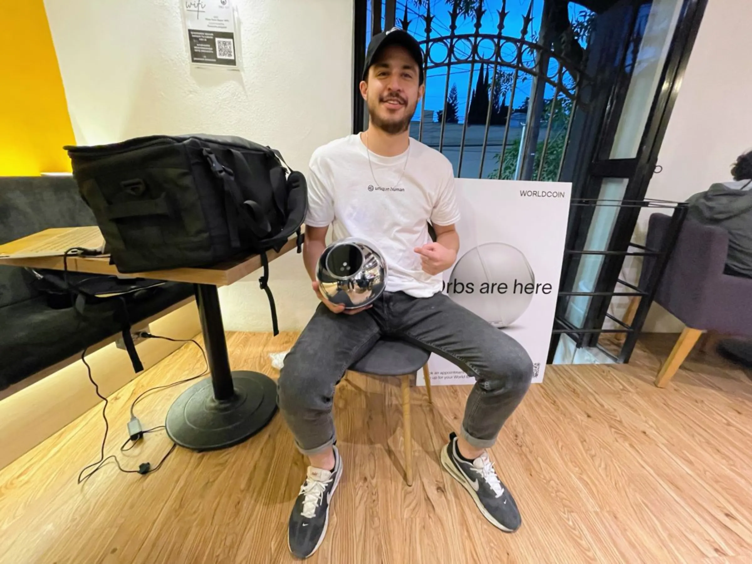 Germán González, a community specialist for Worldcoin, poses with the Orb in a coworking space in Coyoacán, Mexico City. July 24, 2023. Diana Baptista/Thomson Reuters Foundation