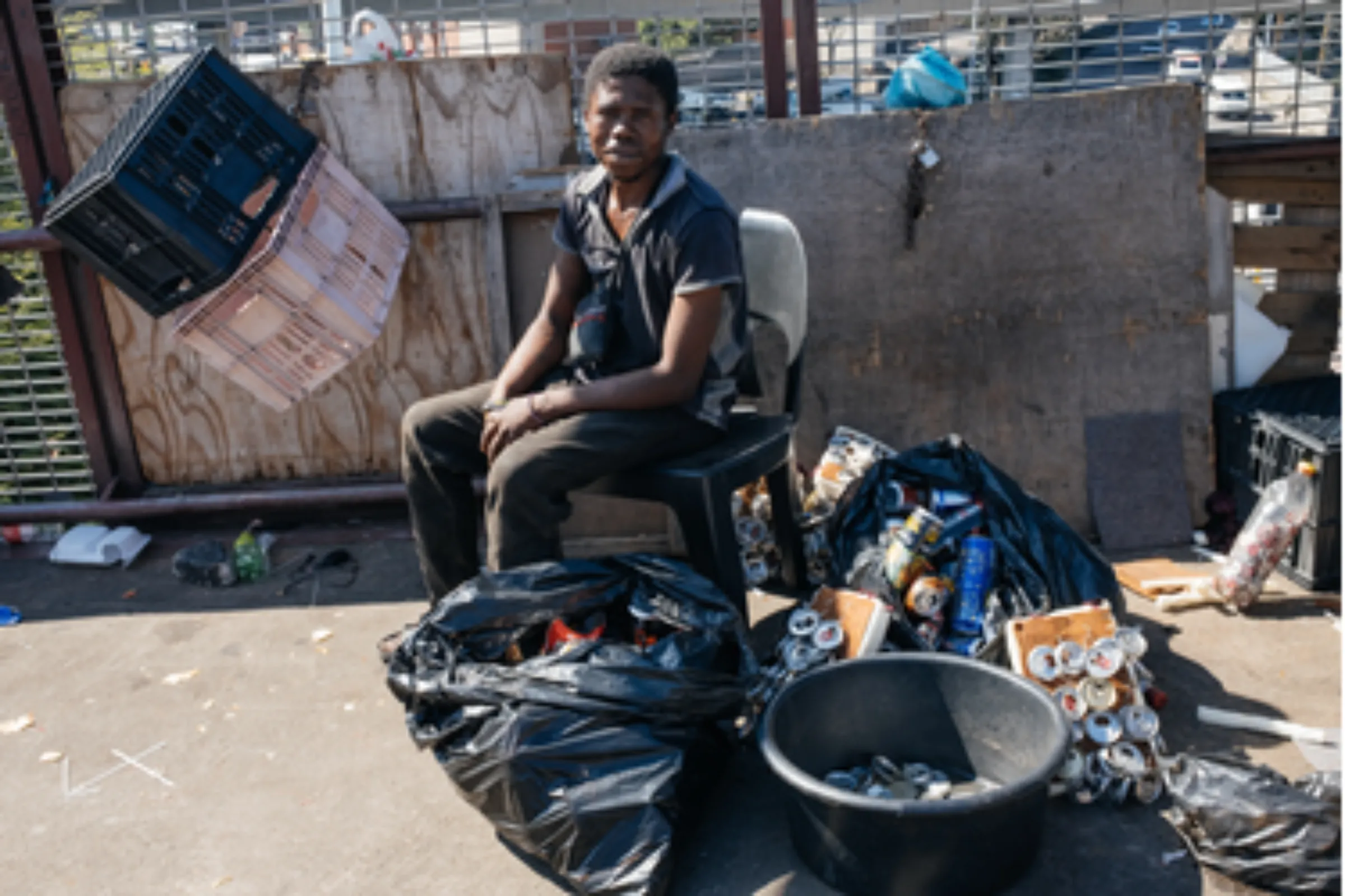 Waste picker Lethukuthula Mnguni, 26, collects cans and cardboard at the Warwick Market in Durban, South Africa, March 31, 2021. Although not formally recognised, Durban's waste pickers help curb climate change by recycling a greater share of the city’s waste. Thomson Reuters Foundation/James Puttick